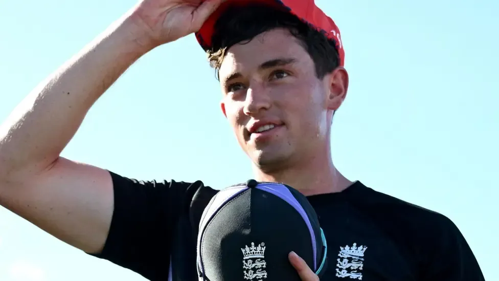 John Turner wearing a blue England top and holding a blue England cap